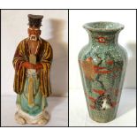 JAPANESE STONEWARE FIGURE OF A SCHOLAR wearing traditional robes and holding a tablet in both hands,