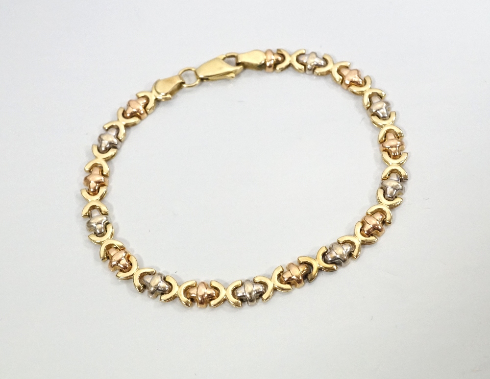 FOURTEEN CARAT THREE TONE GOLD BRACELET with rounded cross and semi-circle shaped links, 17.