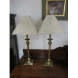 A PAIR OF GILT METAL TABLE LAMPS with reeded columns and pleated shades 74cm high