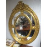 A CONTINENTAL GILTWOOD AND GESSO COMPARTMENT MIRROR of oval outline with foliate and C scroll