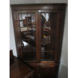 A MAHOGANY DOUBLE DOOR CORNER CABINET with astragal glazed doors between canted angles the base