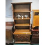 AN OAK OPEN FRONT DRESSER the moulded cornice above four open shelves the base containing a drawer