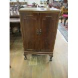 A MAHOGANY SHOE CUPBOARD with panel doors containing chrome rails on claw and ball feet 103cm (h) x