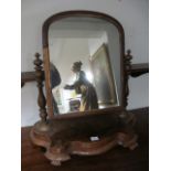 A VICTORIAN MAHOGANY CRUTCH FRAME MIRROR on platform base with scroll toes