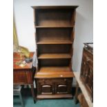 AN OAK OPEN FRONT DRESSER the moulded cornice above four open shelves the base containing a drawer