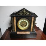 A BLACK SLATE MANTLE CLOCK of architectural outline the rectangular case between reeded Corinthian