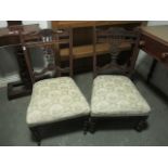 A PAIR OF EDWARDIAN MAHOGANY NURSING CHAIRS with pierced vertical splat on upholstered seat on