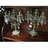 A PAIR OF CONTINENTAL STYLE GILT BRASS FOUR BRANCH CANDELABRA the foliate scroll branches hung with