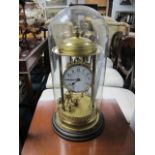 A GILT BRASS SKELETON CLOCK in a glass domed case with wooden turned base