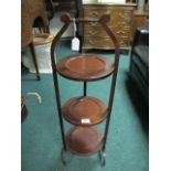 AN EDWARDIAN MAHOGANY THREE TIER FOLDING CAKE STAND on splayed legs 83cm high