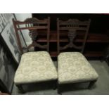 A PAIR OF EDWARDIAN MAHOGANY NURSING CHAIRS with pierced vertical splat on upholstered seat on