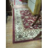 A COTSWOLD COLLECTION RUG the wine and beige ground with central floral panel within a conforming