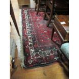 A RECTANGULAR WOOL RUG the red and blue ground decorated overall with geometric motifs 310cm x