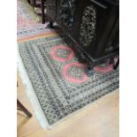 A WOOL RUG the light pink ground with central panels within an eight stripe border 192cm x 130cm