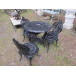 A VICTORIAN STYLE THREE PIECE BLACK PAINTED METAL GARDEN SUITE comprising of a table with circular