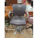 A CHROME FRAMED LEATHER UPHOLSTERED BARBERS CHAIR with adjustable seat