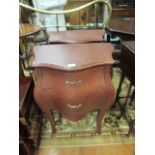 A PAIR OF LEATHER UPHOLSTERED BOMBE SHAPED COMMODES the shaped tops with moulded rims above two