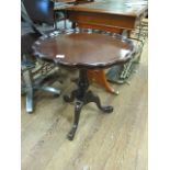 A GEORGIAN STYLE MAHOGANY OCCASIONAL TABLE the circular top with raised waved rim on a ring turned