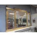 A RECTANGULAR GILT OVER MENTAL MIRROR the moulded frame headed by raised finials with compartmented