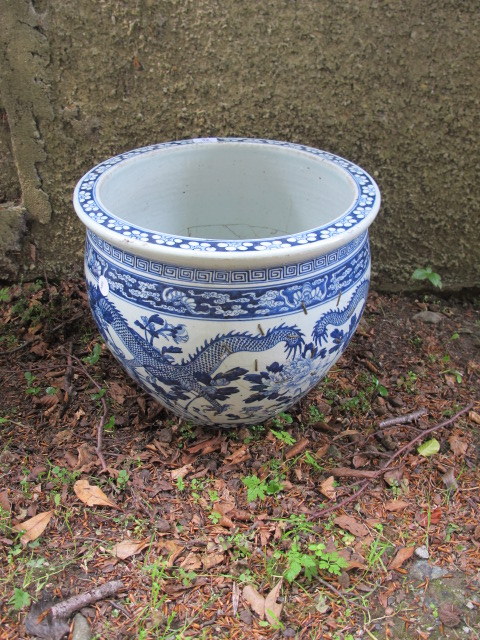 AN ORIENTAL STYLE GLAZED PORCELAIN JARDINIERE the white ground decorated with blue foliates and