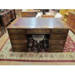 A GEORGIAN STYLE MAHOGANY PEDESTAL DESK the burgandy leather tooled top with moulded rim above a