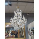 A CONTINENTAL STYLE GILT BRASS AND CUT GLASS TWELVE ARM CHANDELIER the scrolled arms with foliate