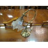 A BRASS TABLE LAMP the scrolled arm and shaped shade on circular graduated foot 33cm