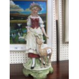 A GLAZED AND PAINTED PORCELAIN GROUP OF A FEMALE FEEDING A DEER shown on a stylized grassy plinth