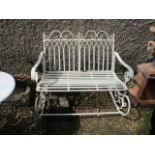 A GREEN PAINTED GOTHIC STYLE WROUGHT IRON ROCKING GARDEN BENCH the rectangular open back headed by