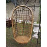 AN ORIENTAL STYLE CANE GARDEN SWING the open work tub shaped back above a circular cane seat 113cm