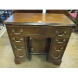 A GEORGIAN MAHOGANY KNEE HOLE DESK rectangular top with moulded rim above a long cock beaded frieze