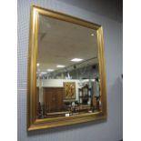 A RECTANGULAR GILT WALL MIRROR the moulded frame with bevelled plate 117cm x 91cm