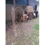 A WROUGHT IRON THREE FOLD ARCHED GARDEN SCREEN the open panels filled with robe twist boughs