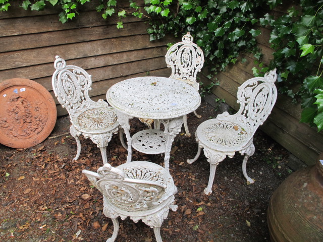 A FIVE PIECE VICTORIAN STYLE WHITE PAINTED GARDEN SUITE COMPRISING OF A CIRCULAR TABLE WITH FULLY