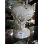 A BELLEEK CONCH SHELL second period raised on a stylized tree stump on a circular base