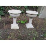 A PAIR OF COMPOSITION STONE PLANTERS with reeded columns on square bases 58cm