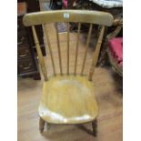 A COUNTRY STYLE LOW CHAIR the wide spindled back with shaped seat on ring turned supports