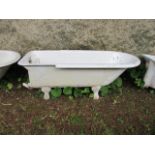 A WHITE ENAMELLED CAST IRON BATH with rounded rim and chrome waste fitting raised on lion paw feet