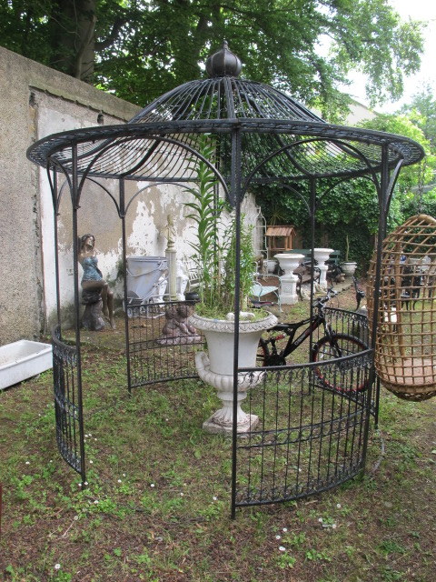 A LARGE ORIENTAL STYLE WROUGHT IRON MARQUEE the open pagoda shaped top headed by an acorn finial