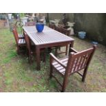 A NINE PIECE WOODEN GARDEN SUITE comprising of a rectangular table with slatted top raised on