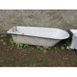 A WHITE ENAMELLED CAST IRON BATH with chrome hot and cold taps and waste stopper raised on lion paw