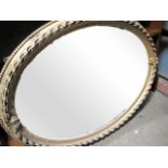 A VICTORIAN GILT PLASTER OVAL OVER MANTEL MIRROR with ribboned and beaded frame