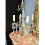 A PAIR OF CONTINENTAL STYLE GILT BRASS AND CUT GLASS four light candelabra,