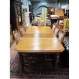 A LATE VICTORIAN OAK EXTENDING DINING TABLE together with six matching carver chairs on turned