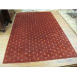 A RECTANGULAR WOOL RUG the red ground decorated overall with gold foliate motifs 201cm x 293cm
