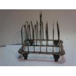 GIII silver six-slice toast rack with ring-handle, shell corners, gadrooned border, on four feet.