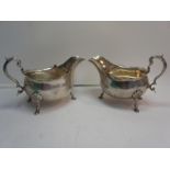 Pair of late Victorian silver sauce boats with shaped borders, scroll handle, shell knees and hoof