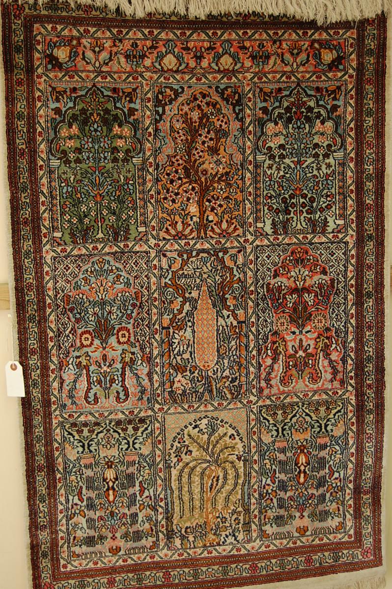 A fine silk garden carpet with nine panels showing flora and fauna, 51 x 33ins.