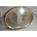 A Victorian oval silver tea tray with scroll handles, gadrooned border with engraved decoration of