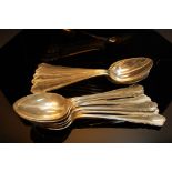 Twelve GIV matching silver pudding spoons with shaped tops, Sheffield 1939 and 1940, 24ozt